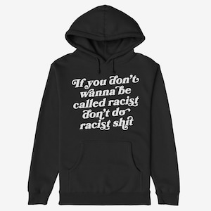 May include: Black hooded sweatshirt with a front pocket and a hood. The sweatshirt features the text "If you don't wanna be called racist don't do racist shit" in white, stylized lettering.