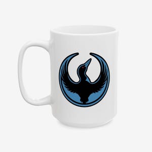 May include: White ceramic mug featuring a black bird design with blue accents. The bird is depicted with outstretched wings inside a blue circle. The mug has a large handle and is suitable for hot or cold beverages.