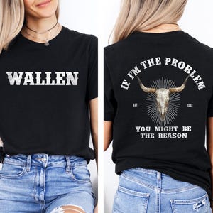 Peut inclure: T-shirt noir avec le nom "WALLEN" en lettres blanches délavées sur le devant. Le dos du t-shirt présente un graphisme de crâne avec des cornes et le texte "IF I'M THE PROBLEM YOU MIGHT BE THE REASON."