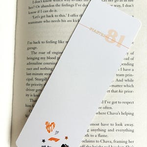 May include: White bookmark with orange text and graphics. The bookmark features the name "PIASTRI" and the number "81" in orange, along with small racing-themed icons. The McLaren logo is also visible.