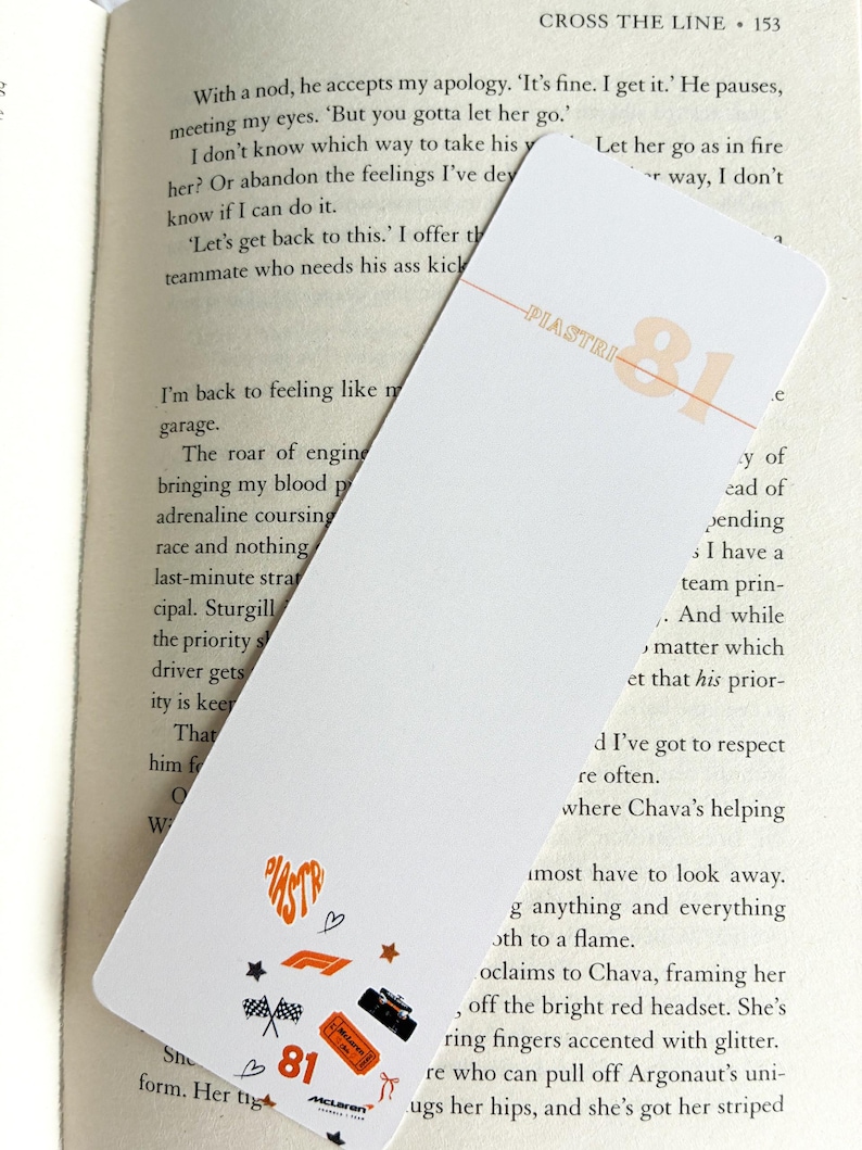 May include: White bookmark with orange text and graphics. The bookmark features the name "PIASTRI" and the number "81" in orange, along with small racing-themed icons. The McLaren logo is also visible.