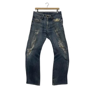 K&ouml;nnte beinhalten: Dunkelblaue Jeans mit Used-Details, h&auml;ngen an einem Holzkleiderb&uuml;gel. Die Jeans haben ein klassisches F&uuml;nf-Taschen-Design und ein leicht ausgestelltes Bein. Die Used-Bereiche haben ein verwaschenes Aussehen.