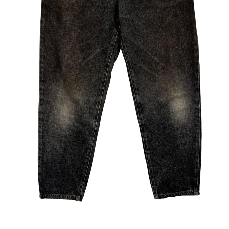 Puede incluir: Un par de vaqueros de mezclilla gris oscuro. Los vaqueros tienen un aspecto descolorido con parches m&aacute;s claros en los muslos y las rodillas. La mezclilla es de peso medio, con costuras visibles y un dise&ntilde;o cl&aacute;sico de cinco bolsillos.