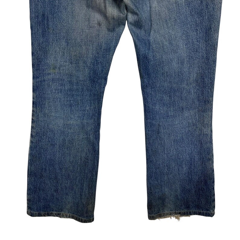 K&ouml;nnte beinhalten: Verblasste blaue Jeans mit leichtem Bootcut. Die Jeans weisen Abnutzungserscheinungen auf, mit Verf&auml;rbungen und ausgefransten Kanten am unteren Saum. Der Denim hat einen klassischen, Vintage-Look.