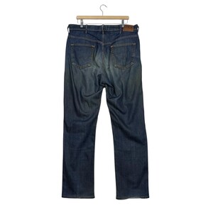 K&ouml;nnte beinhalten: Dunkelblaue Jeans an einem Holzb&uuml;gel. Die Jeans haben ein klassisches F&uuml;nf-Taschen-Design, einen Knopf- und Rei&szlig;verschluss und einen Lederaufn&auml;her auf der R&uuml;ckseite. Die Jeans sind im Straight-Leg-Stil.
