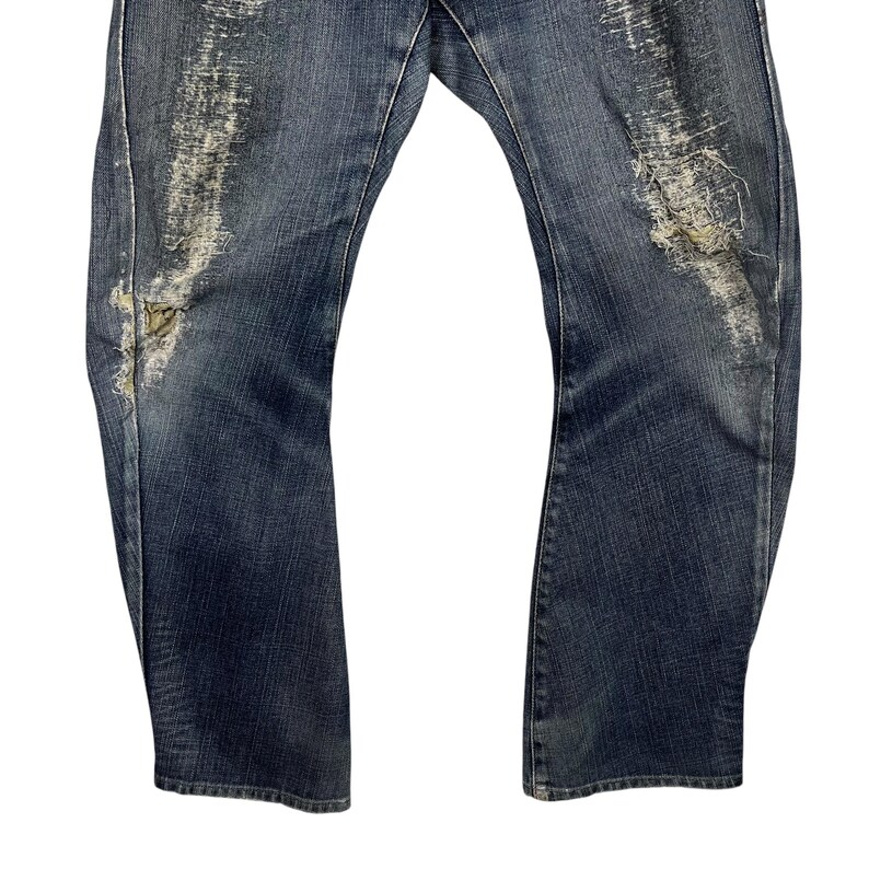 K&ouml;nnte beinhalten: Verblasste blaue Jeans mit Distressed-Details. Die Jeans haben gerissene Bereiche mit freiliegenden F&auml;den und ein abgenutztes Aussehen. Der Denim hat eine mittlere Waschung mit helleren Bereichen durch Abnutzung. Die Jeans haben ein klassisches F&uuml;nf-Taschen-Design.