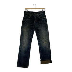 May include: Dark wash denim jeans with a distressed look, featuring a knee rip and rolled-up cuffs. The jeans are hanging on a wooden hanger against a white background. The jeans appear to be a straight-leg style.