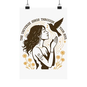 Puede incluir: Un póster con una mujer y un pájaro, con el texto "THE UNIVERSE SINGS THROUGH YOUR SOUL". El diseño incorpora detalles dorados y elementos florales. La obra tiene un tema espiritual y artístico, con los brazos de una mujer levantados.