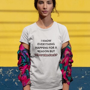 May include: A white t-shirt with the text "I KNOW EVERYTHING HAPPENS FOR A REASON BUT What The Fuck?". The person is wearing a colorful jacket with pink, blue, and green accents. The background is yellow and blue.
