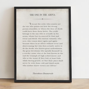 May include: A black and white printable quote by Theodore Roosevelt about the importance of action and striving for greatness. The quote is printed on a textured background and framed with a black frame.