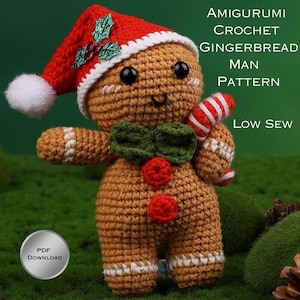 May include: A crocheted gingerbread man amigurumi wearing a red Santa hat with a white pom-pom and holly. The gingerbread man has a green bow tie, red buttons, and a candy cane. The image text reads "Amigurumi Crochet Gingerbread Man Pattern Low Sew".