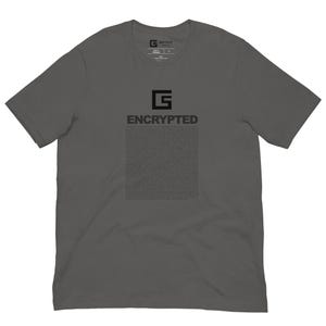 May include: Dark gray t-shirt with the word "ENCRYPTED" printed in black, along with a graphic and a block of text. The shirt has a crew neck and short sleeves. The brand logo is visible on the upper back.