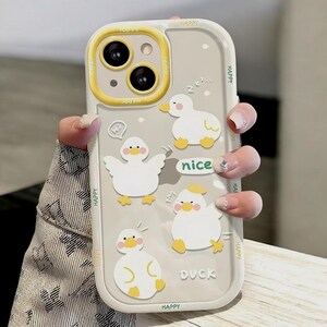May include: A clear phone case with a yellow border and a cutout for the camera. The case has a cartoon design of ducks with the words "Happy", "Nice", and "Duck" printed on it.