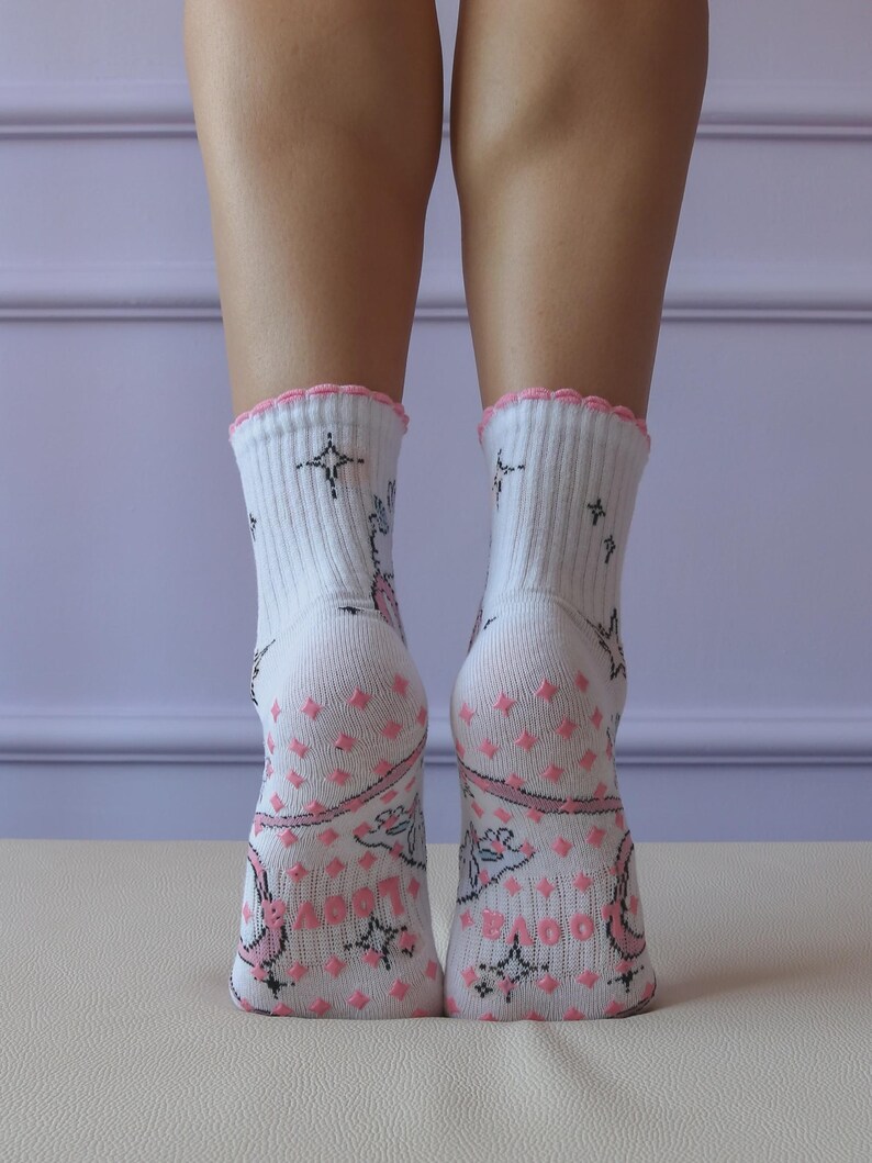 May include: White socks with pink accents and a scalloped edge. The socks feature a pattern of pink diamonds, stars, and floral designs. The socks are ribbed at the top and have a soft, comfortable appearance.