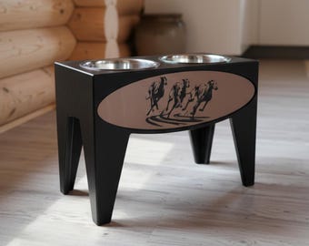 May include: Black dog bowl stand with two stainless steel bowls. The stand has a brown oval panel with a silhouette of running dogs. The stand is made of wood and has four angled legs. A decorative and functional item for pet owners.