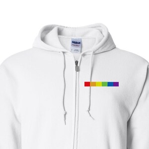 May include: White zippered hoodie with a rainbow stripe on the left chest.