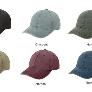 May include: A collection of six baseball caps in various colors: black, charcoal, hunter green, khaki, maroon, and navy blue. Each cap has a curved brim and a fabric strap closure at the back. The names of the colors are displayed below each cap.