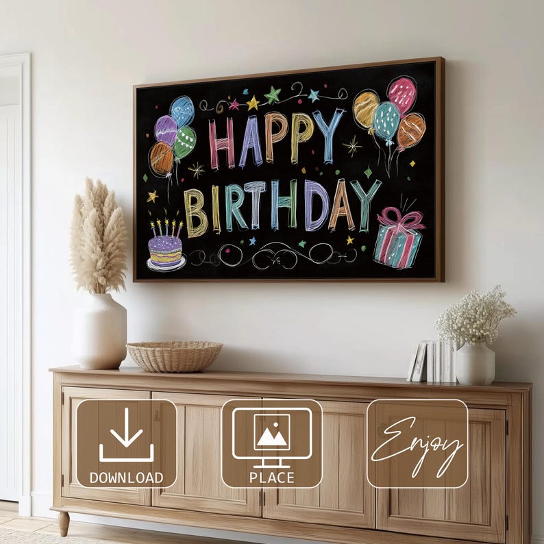 May include: A framed chalkboard with the words "HAPPY BIRTHDAY" in colorful chalk lettering. The design includes balloons, stars, a cake with candles, and a wrapped gift. The chalkboard is displayed above a wooden cabinet.