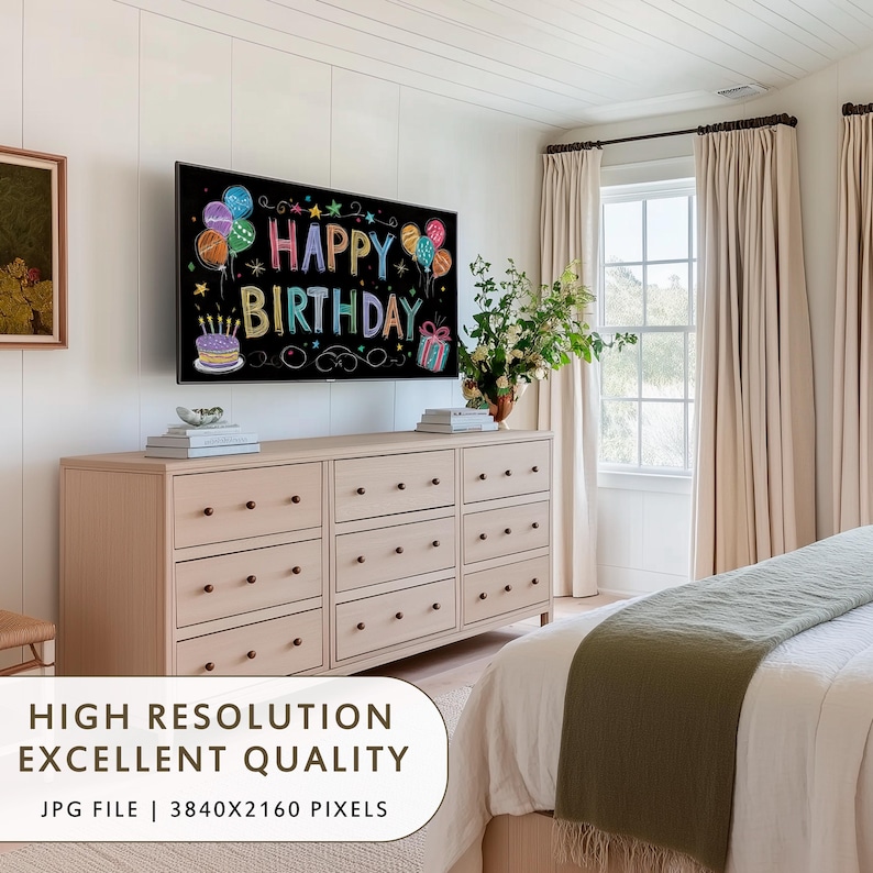 May include: A bedroom scene with a large TV displaying "Happy Birthday" in colorful chalk-style lettering. The TV is mounted above a light wood dresser with multiple drawers. The room has neutral tones, with beige curtains and a white bedspread.