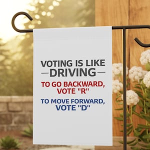 Könnte beinhalten: Eine weiße Gartenflagge mit schwarzem Text, der lautet: "VOTING IS LIKE -DRIVING- TO GO BACKWARD, VOTE 'R' TO MOVE FORWARD, VOTE 'D'". Die Flagge hängt an einem schwarzen Metallständer in einem Garten.