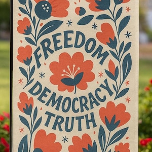 May include: A beige garden flag featuring a floral design and the words "FREEDOM DEMOCRACY TRUTH" in a circular pattern. The flowers are orange, the leaves are dark blue, with star accents.