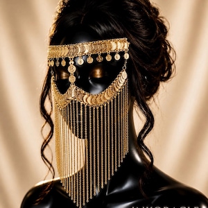 May include: A gold-toned metal face mask featuring a horizontal band of circular coin-like charms across the forehead and a scalloped section over the eyes, with long, delicate hanging chains that drape down to cover the lower face area.