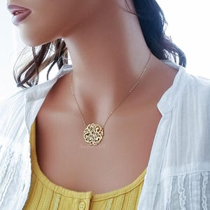 Pode incluir: Um colar de ouro com um delicado e intrincado pingente circular com um design de filigrana. O pingente &eacute; feito de uma &uacute;nica pe&ccedil;a de metal e tem um toque delicado e arejado.
