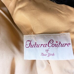 May include: A white tag with the text "Futura Couture of New York" in purple script.