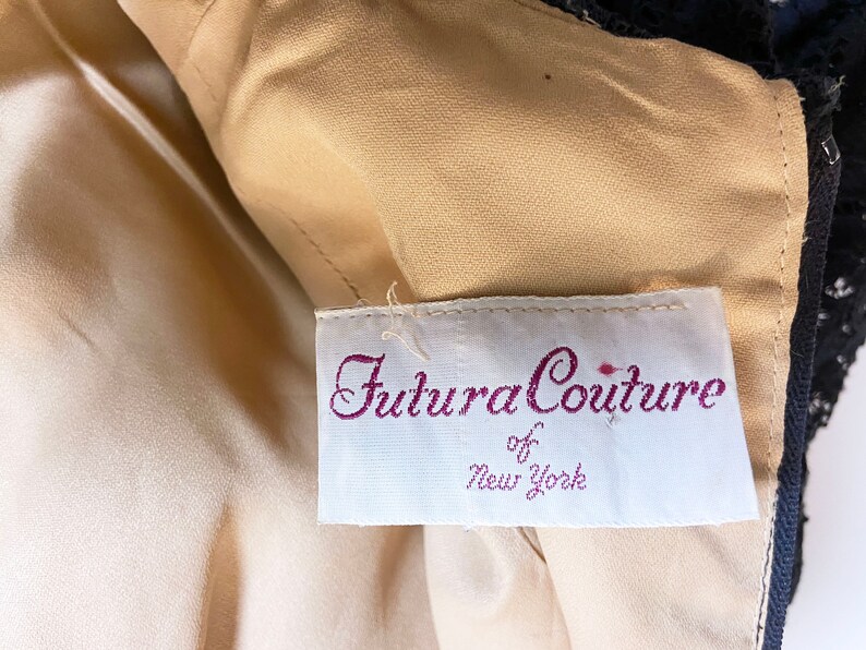 May include: A white tag with the text "Futura Couture of New York" in purple script.