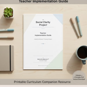 May include: A teacher's implementation guide titled "The Social Clarity Project" with the text "Teacher Implementation Guide" is displayed on a wooden surface. The guide is accompanied by a succulent plant, pens, a notebook, and a cup of coffee.