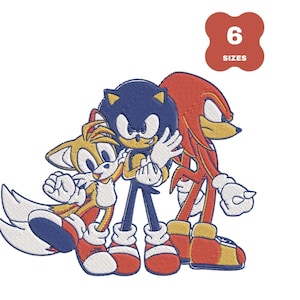 Op de afbeelding: Geborduurde patch met Sonic the Hedgehog, Tails en Knuckles. De personages zijn in hun klassieke ontwerpen, met blauwe, gele en rode kleuren. Een rood label in de rechterbovenhoek geeft "6 SIZES" aan.