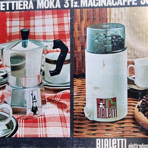 Può includere: Set vintage Bialetti composto da caffettiera Moka e macinacaffè. La caffettiera Moka è argentata con manico e coperchio neri. Il macinacaffè è bianco con coperchio trasparente e logo Bialetti rosso e verde. L'immagine include chicchi di caffè e tazze.