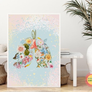 以下が含まれることがあります： 花柄の肺のデザインが施された額入りのアートプリント。肺は、明るい青とピンクの斑点のある背景に、カラフルな花と葉で満たされています。アートワークは白い壁に展示されています。