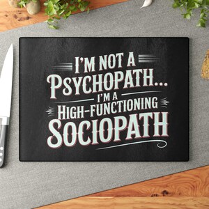 May include: Black rectangular cutting board with the text "I'M NOT A PSYCHOPATH... I'M A HIGH-FUNCTIONING SOCIOPATH" in white and red lettering. The cutting board is on a wooden surface with a knife.