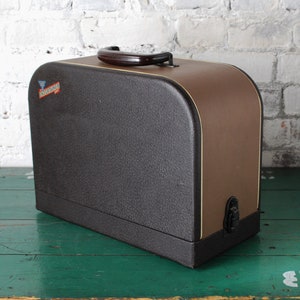 May include: A brown and black vintage sewing machine case with a metal latch and a "Silhouette" label on the side.