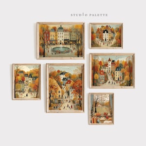 以下が含まれることがあります： 秋の街並みを描いた額入りのアートプリントのコレクション。アートワークは、建物、紅葉した木々、人物を描いています。カラーパレットは、オレンジ、黄色、茶色の暖色系で、青色が少し入っています。「STUDIO PALETTE」の文字が見えます。