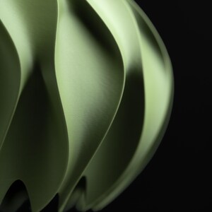 May include: A light green pendant light shade featuring a series of vertical, curved, and undulating fins that create a rhythmic, wave-like pattern. The structure has a smooth, matte finish and a rounded, bulbous form against a black background.