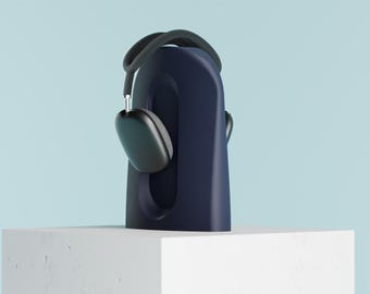 May include: A dark navy blue, smooth, arched headphone stand with a central vertical cutout. Resting on top of the stand is a pair of dark gray over-ear headphones with a flexible headband and metallic silver accents on the ear cup connectors.