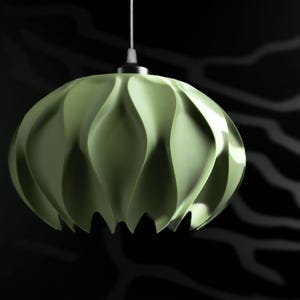 May include: A pale green pendant light fixture with a rounded, multi-faceted shape featuring deep, vertical, wave-like folds. The lamp is suspended by a thin white cord attached to a metallic silver cap at the top center of the structure.