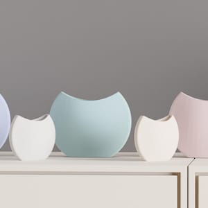 May include: Five pastel-colored, modern ceramic vases in varying sizes. The vases are in shades of lavender, white, seafoam green, and pink. Each vase has a unique, curved opening. They are arranged on a white surface against a gray background.