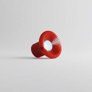 May include: A red lamp with a cylindrical base and a wide, flared shade composed of thin, vertical slats. The shade features a circular opening at the center, revealing a smooth, white, spherical light bulb emitting a soft glow from within.
