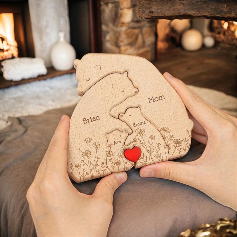 Puede incluir: Rompecabezas familiar de osos de madera con los nombres "Brian", "Mom", "Emma" y "Ava" grabados. El rompecabezas presenta un coraz&oacute;n rojo y detalles florales. Hecho de madera clara.