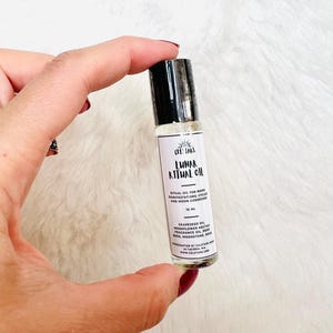 May include: A small, clear glass roller bottle with a black cap. The label reads "Lunar Ritual Oil" and lists ingredients and the brand name "Celestars". The bottle contains 10 ml of oil.
