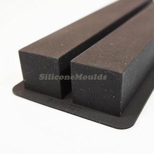 May include: A black silicone mould with two rectangular cavities. The mould is designed for making soap bars or other crafts.