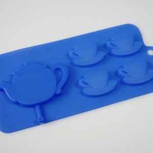 May include: Blue silicone mold for making chocolate teacups and a teapot. The mold has four teacup and saucer molds and one teapot mold.