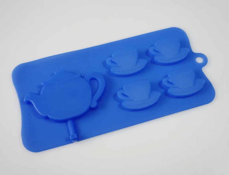 May include: Blue silicone mold for making chocolate teacups and a teapot. The mold has four teacup and saucer molds and one teapot mold.
