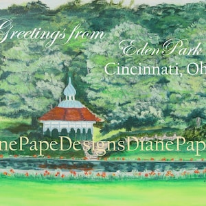 Peut inclure: Une peinture représentant un kiosque avec un toit rouge et des colonnes blanches, entouré d'arbres verts et d'un étang avec des fleurs rouges. Le texte "Greetings from Eden Park Cincinnati, Ohio" est écrit en cursive blanche en haut de l'image. Le texte "Diane Pape Designs Diane Pape" est écrit en cursive blanche en bas de l'image.