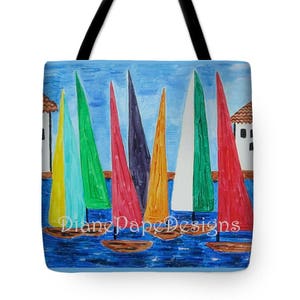 May include: A tote bag featuring a painting of sailboats with colorful sails against a blue sky. The sails are various colors, including yellow, green, red, and white. The bag has black handles and the text "Diane Pape Designs" is visible.
