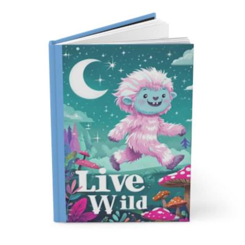 May include: A blue journal with a pink and blue yeti illustration and the text "Live Wild" on the cover. The yeti is walking on a green background with stars and a crescent moon.