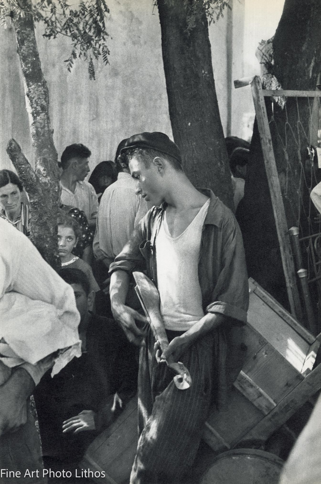 Henri Cartier-Bresson - At The Market In Zugdidi Young Man Idly Strumming A Musical Instrument Not Unlike A Guitar | Black and White Photo